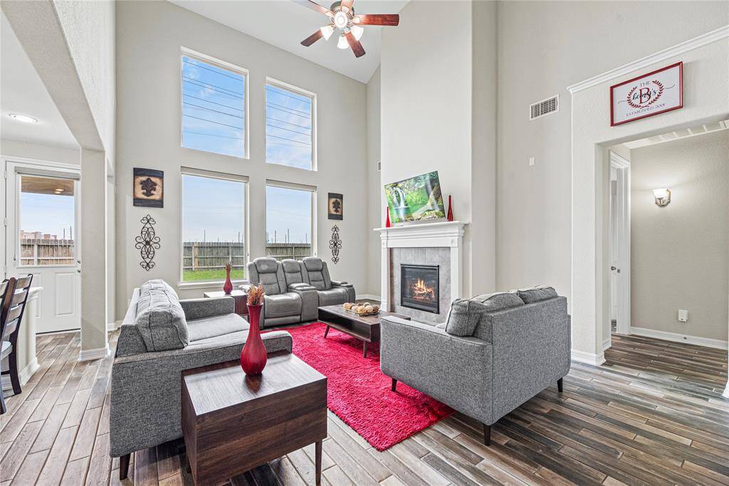Now into the living space. This is such a comfortable space to relax, visit and just be with family. Sun-drenched with natural light and dramatic two-story ceilings, cozy fireplace, tons of charm.
