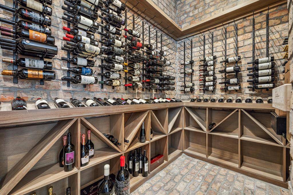 Wine room walls and floor are clad with reclaimed old Chicago brick.  The racks were custom built using metal and mahogany.  The wine room is controlled with a remote cooling system.