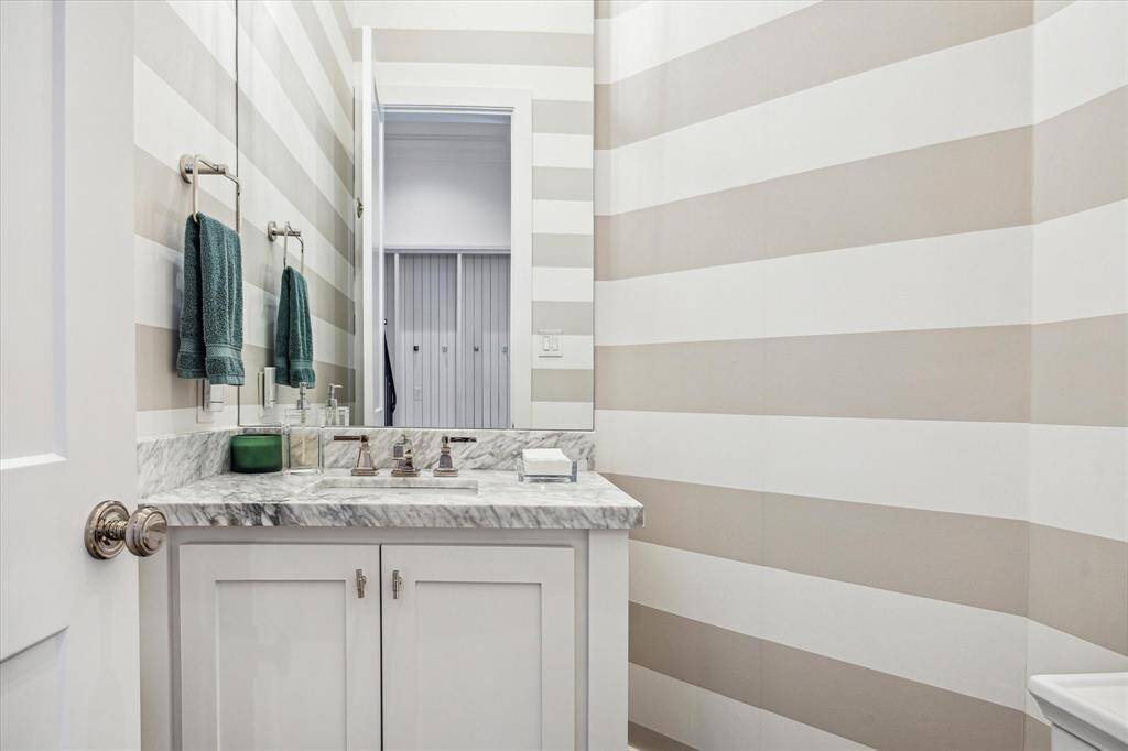 Stylish pool bath conveniently placed adjacent to the backyard door, mud room.