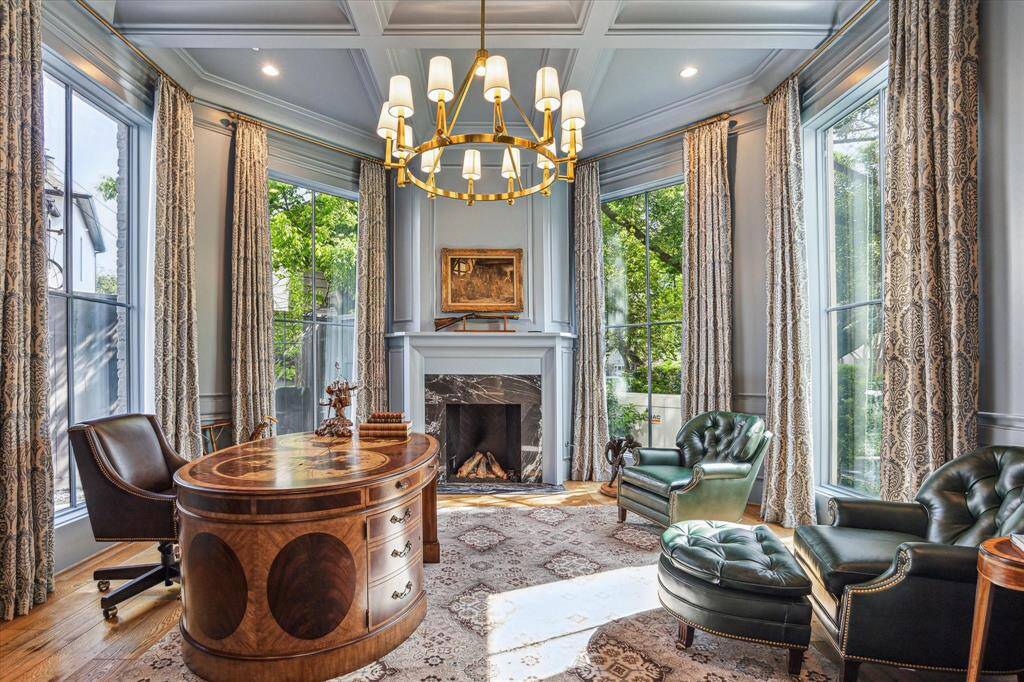 The beautifully designed library features beautiful floor-to-ceiling windows, a marble surround gas fireplace, a coffered ceiling , and custom floor-to-ceiling bookcases and cabinetry(not pictured).