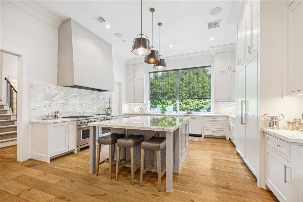 Statuario Corchia marble island and countertops lend an elegant feel to this sensational kitchen,  while providing amazing prep and entertaining space.  The breakfast bar is an cozy spot to enjoy quick breakfast or afternoon snack.