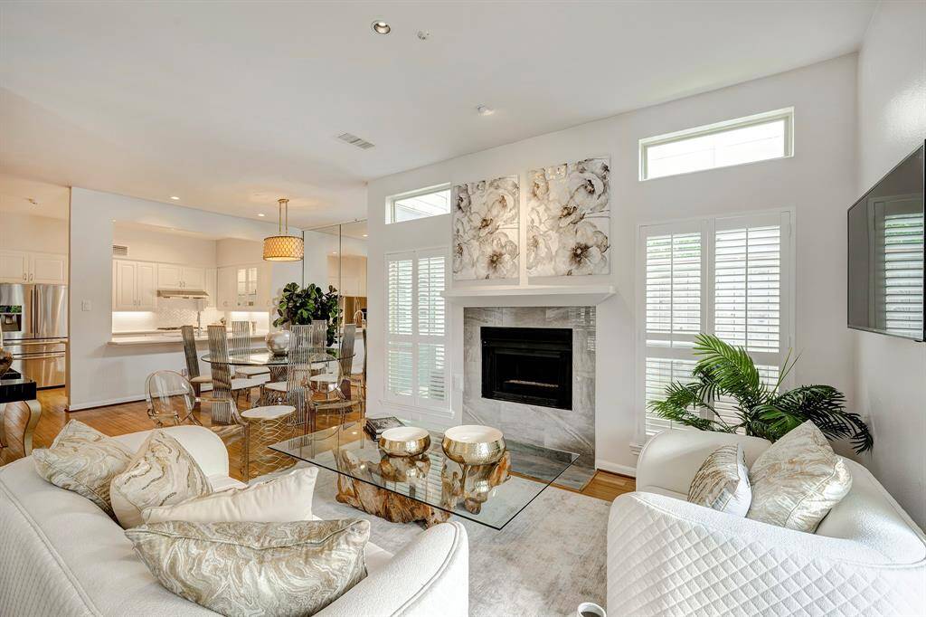 Light and bright living room open to the dining and kitchen. Wood burning fireplace. Transom windows for added natural light. Place for TV