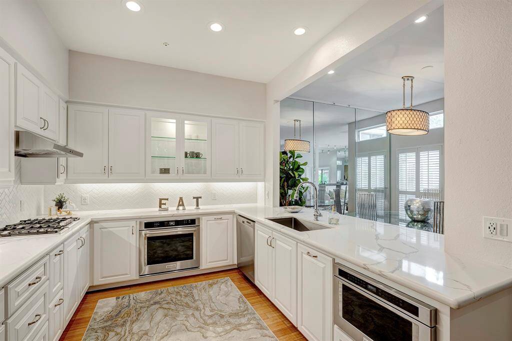 O la la what a kitchen. Glass shelves with cabinet lights add 'gloss", Beautiful counters and cabinetry and appliances. gas cooktop about 2 years old. Recessed lights added.