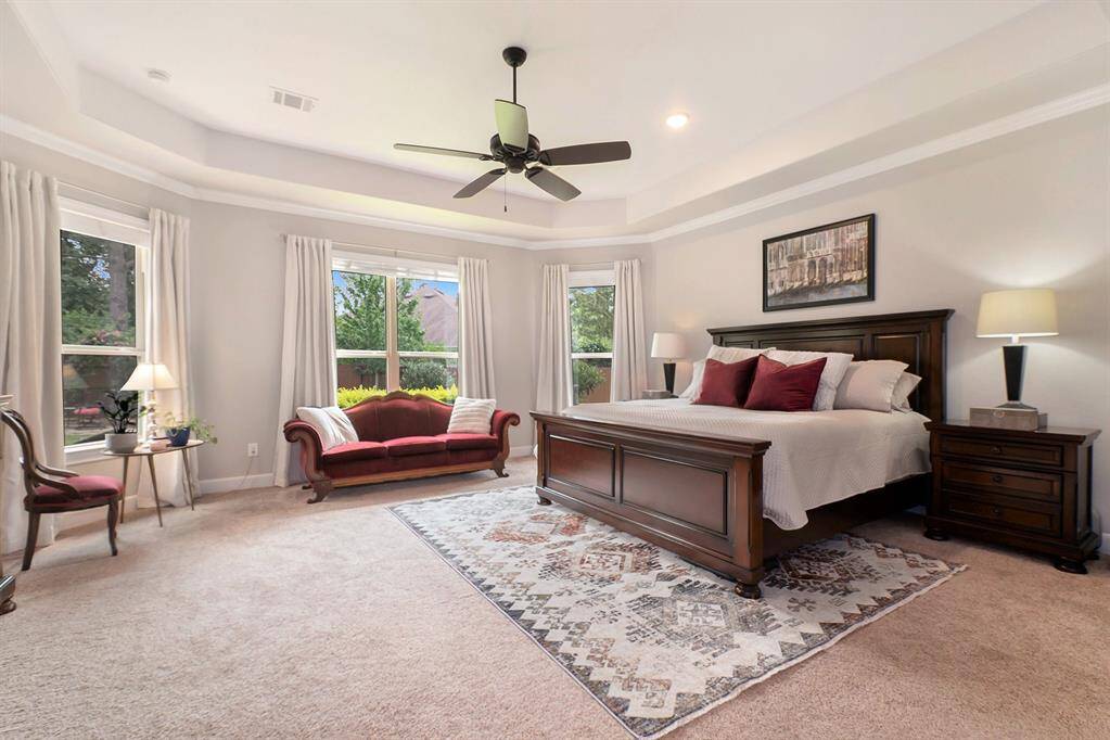 Primary Bedroom with sitting area and backyard views