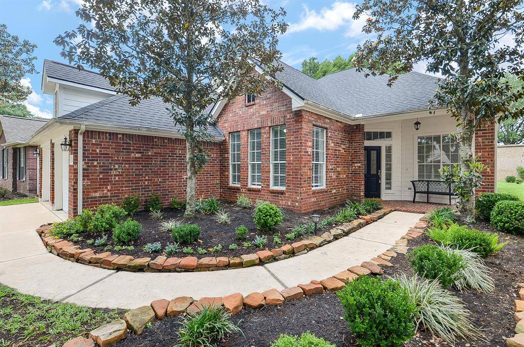 Impeccable landscaping and pristine walkway delight both family and guests, as they arrive at the covered front entrance.