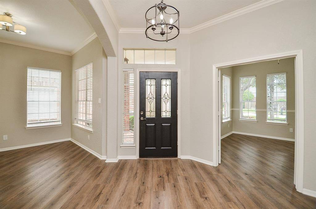 This is the sublime front entrance from the tranquil inside foyer, where peaceful earth toned walls meet beautiful wood laminate flooring; a high ceiling, and lots of natural light, filtering into fabulous front rooms, left and right. Inside, are 3 bedrooms and 2 baths, all gracing an 8,053 square-foot lot with 2.017 square-feet of interior space.