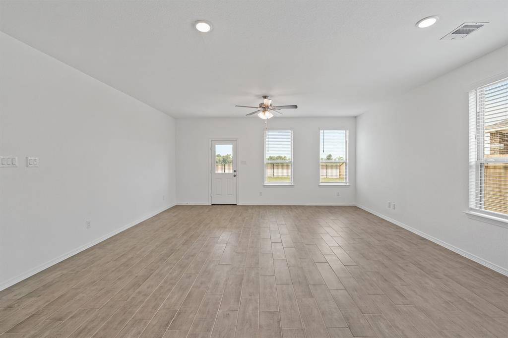 Divine Dining Area and Lovely Living Room offers natural lighting from windows, terrific tile flooring, and allows for ease of access to the Beautiful Backyard!