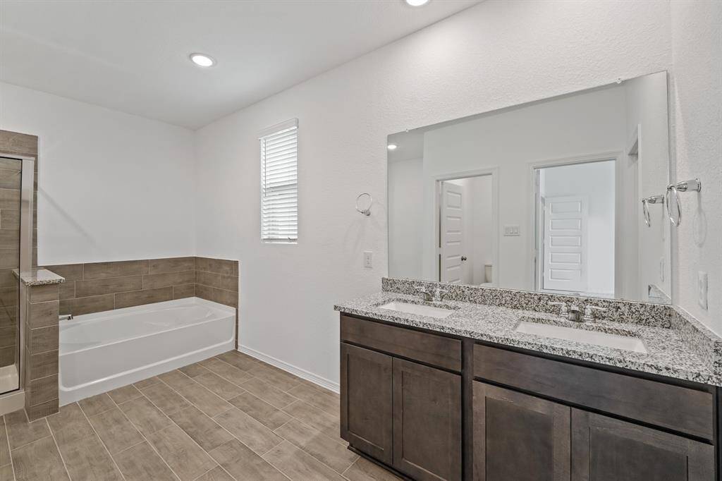 Primary Bath Oasis offers terrific tile flooring, separate Soaking Tub, Glass encased shower and dual sinks that will ensure getting ready in the morning is a breeze!