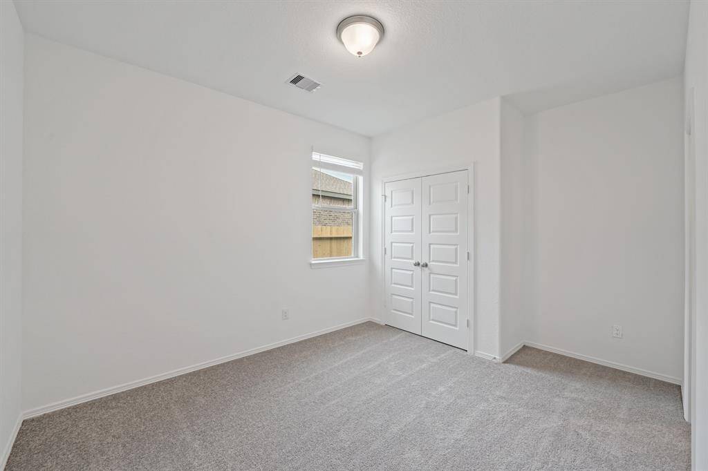 A look into another Serene Secondary Bedroom that offer plush carpeting, natural lighting from window.