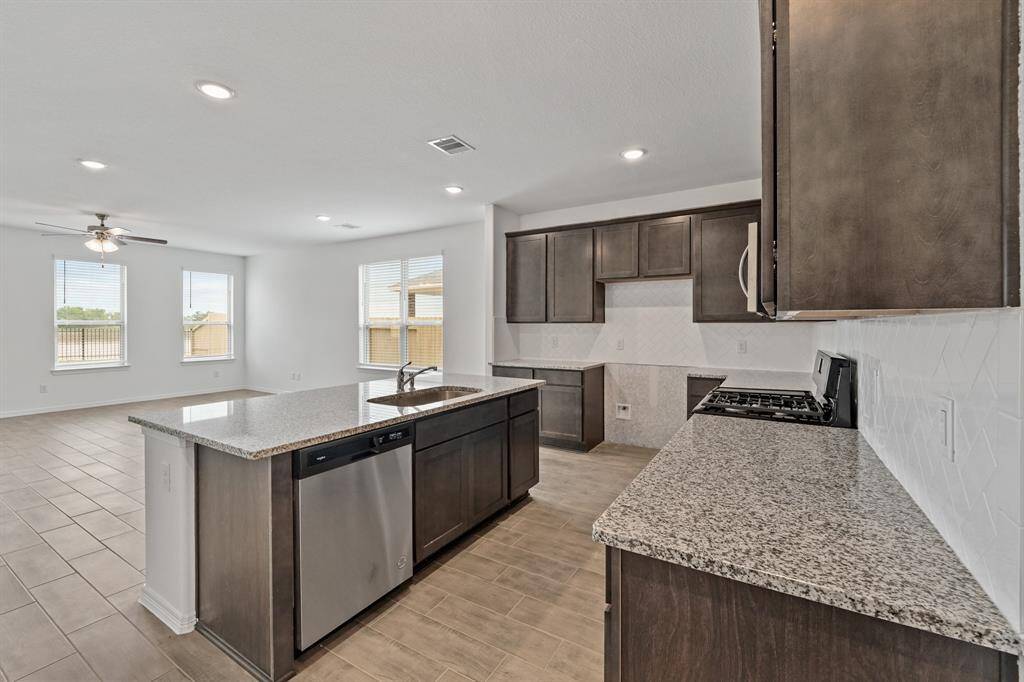 Another view of the open floor plan showcasing the Gourmet Kitchen with Granite Island and adjoining the Luxurious Living Room and Dining Area.