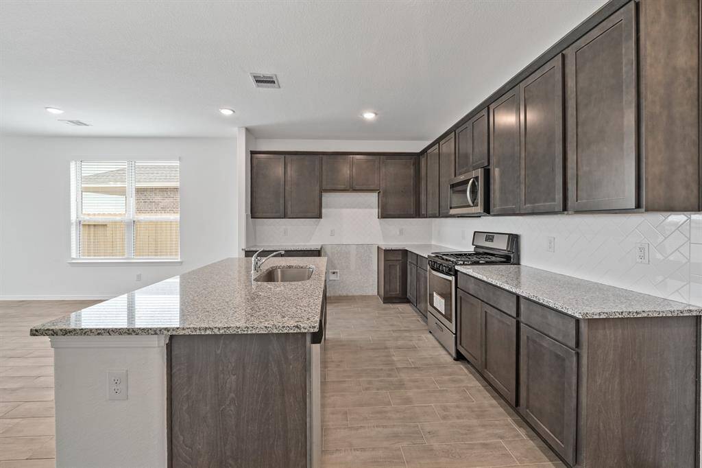 Another view of the Gourmet Kitchen that is accompanied with Stainless Steel Appliances and handsome cabinetry that provides enough storage space to hold all of your kitchen needs!
