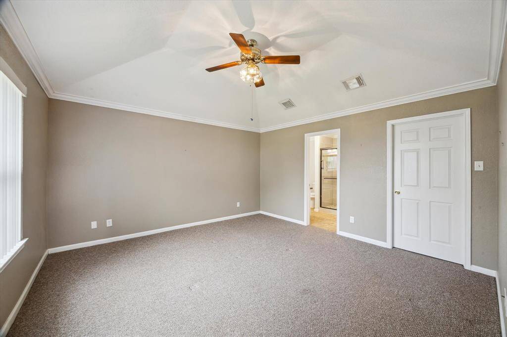 LARGE PRIMARY SUITE OFFERS A LARGE WALK-IN CLOSET, CROWN MOLDING AND CEILING FAN- WALL OF WINDOWS WITH VIEWS OF THE BACK YARD