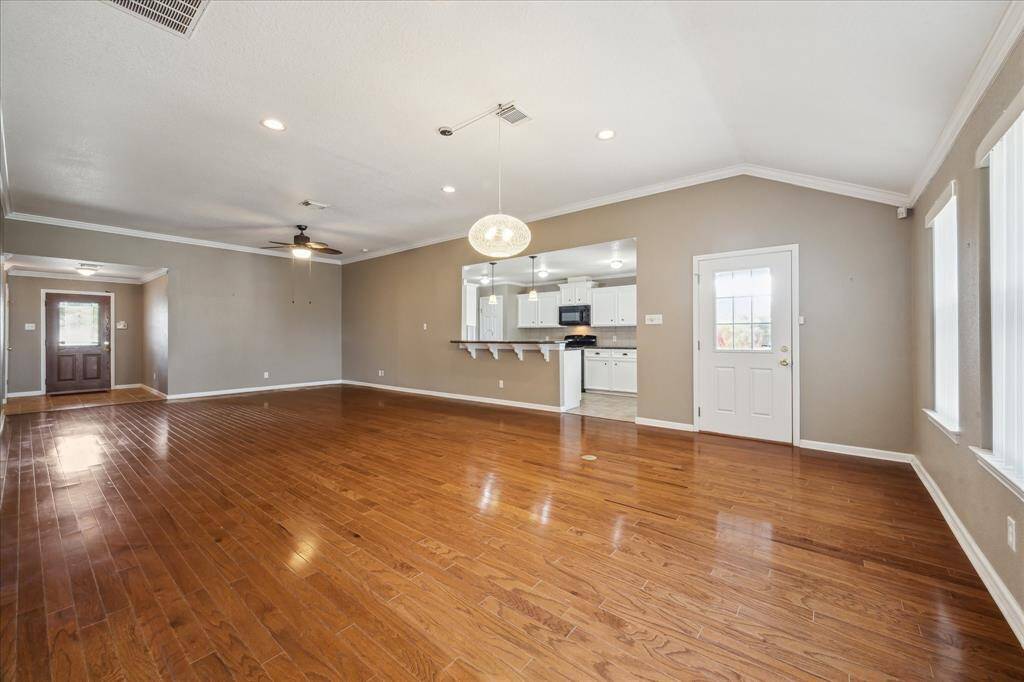 THE DINING AREA SITS UNDER THE CHANDELIER/ BREAKFAST BAR OFF OF THE KITCHEN ADDS SEATING FOR GUESTS/ BRIGHT LIGHTS SHINE THROUGHOUT THE OPEN FLOOR PLAN