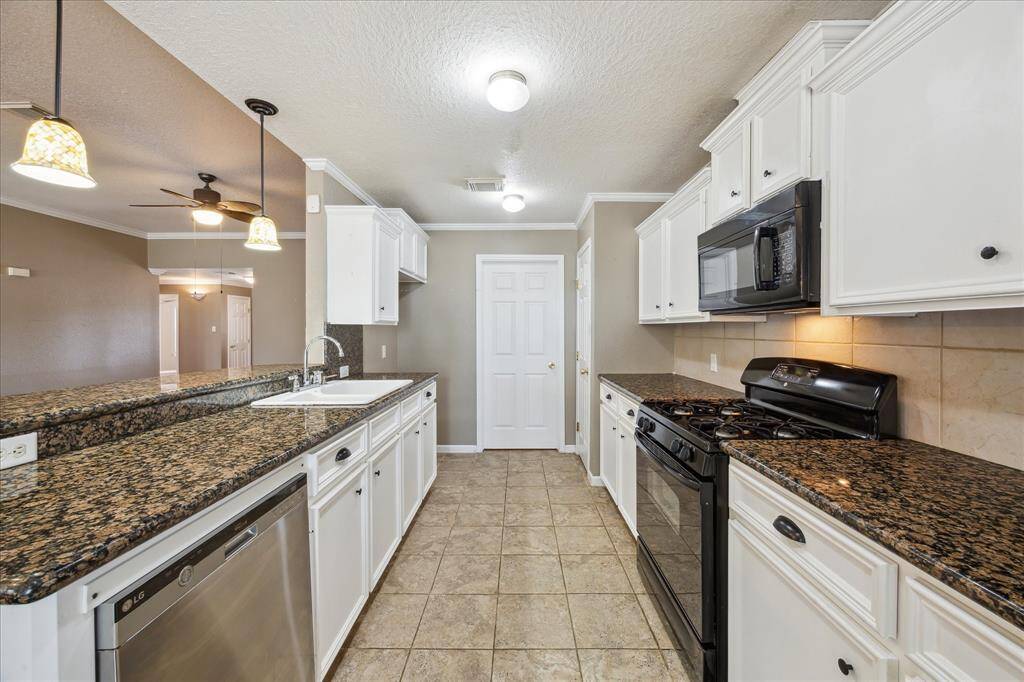 STUNNING KITCHEN OFFERS GAS RANGE AND PENDANT LIGHTING