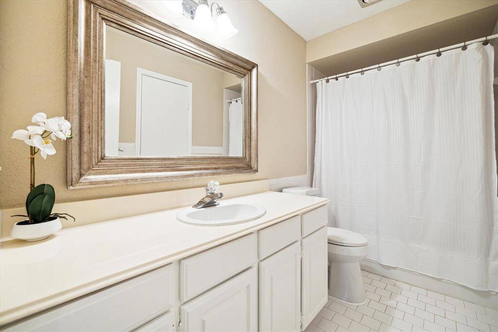 Guest bathroom has lots of counter space and a tub/shower combination.
