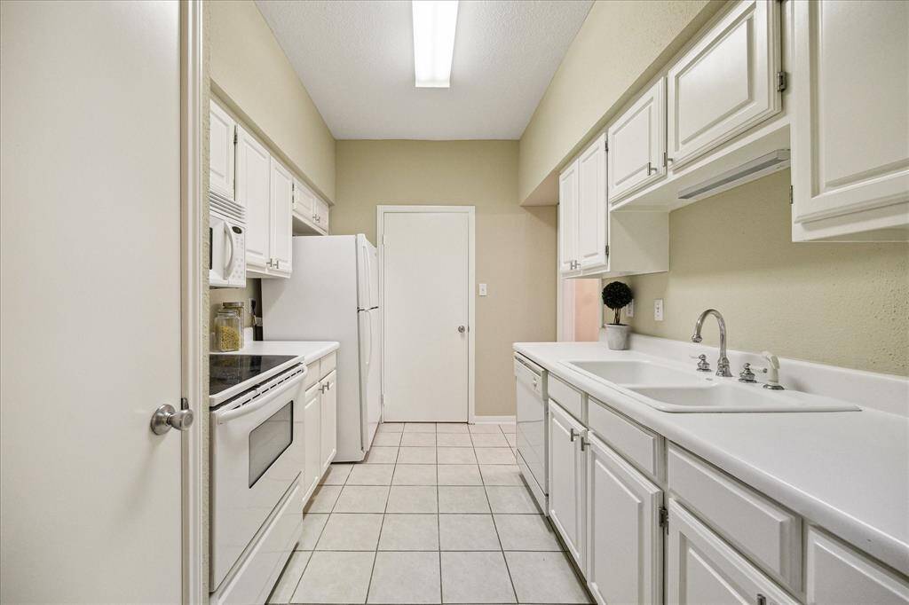 Galley kitchen with laundry room behind the door.