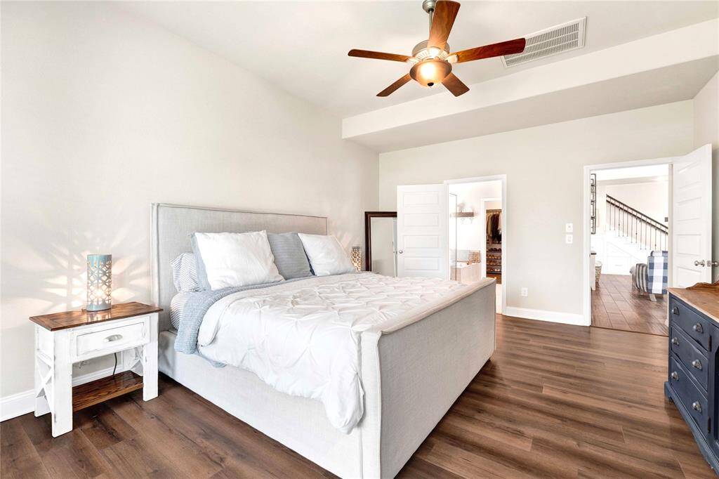 Luxury vibes with upgraded flooring extending into primary bedroom