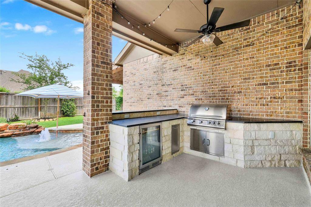 Luxury complete outdoor kitchen with fridge, pull out trash, high end countertops and stone finish