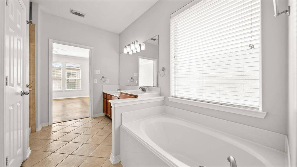 This master ensuite has a free standing tub, and a window with privacy blinds.