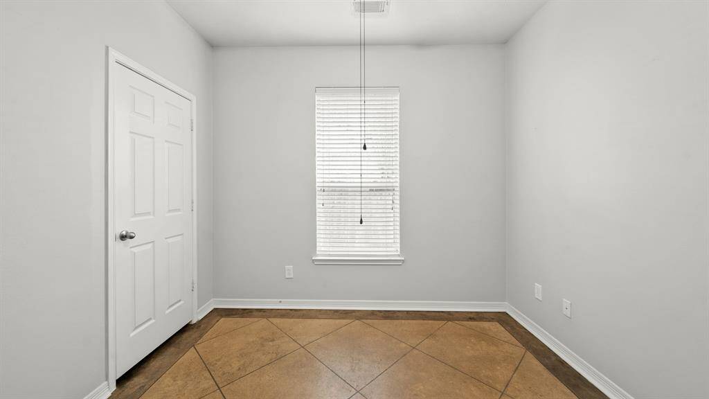 Secondary bedroom with tile floors, a ceiing fan, a window with privacy binds, and a built-in closet.