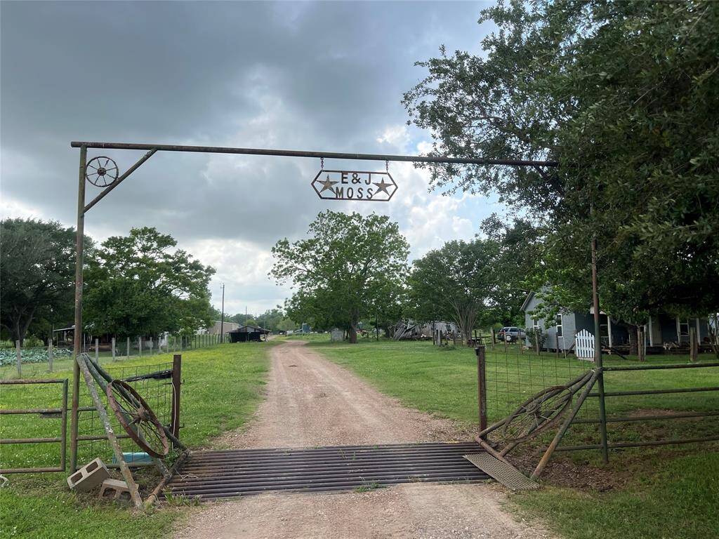 Property entrance surrounded by lush greenery and trees, creating a serene countryside atmosphere.