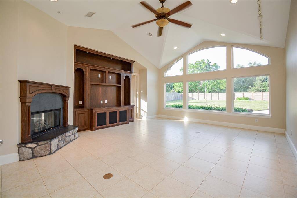 This is your spectacular, brightly lit, softly hued, living/family area with its heavenly high, vaulted ceiling. The huge chocolate colored, built-in wall unit is complemented by the stone-based fireplace which is sure to warm spirits in any temperature.