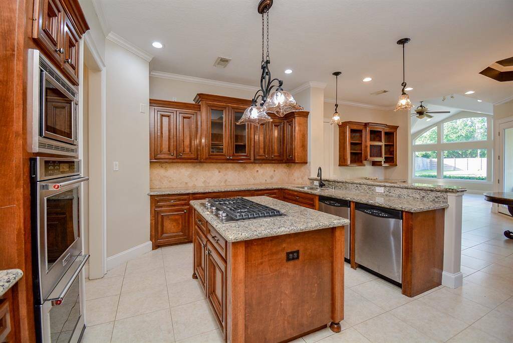 Fully and beautifully equipped, this gorgeous gourmet kitchen offers every comfort and convenience, all overlooking your bright backyard, via arched, wall-wide windows.