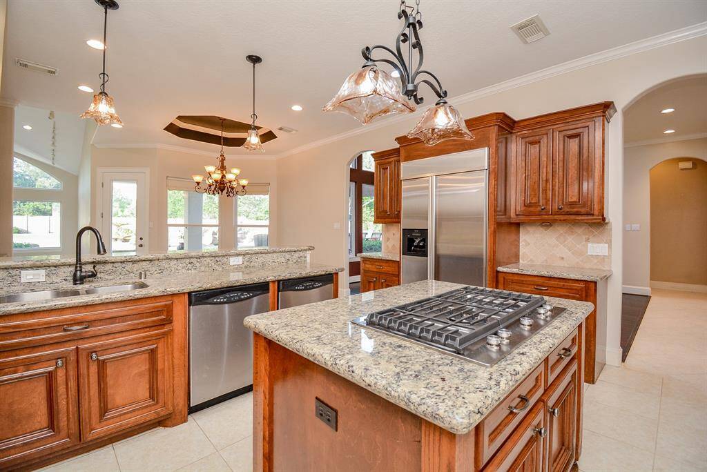 Shining stainless steel appliances (with some doubles?) add to the appealing, open glow of this marvelous space. This sturdy, set in cooktop, graces the luscious granite, island countertop.