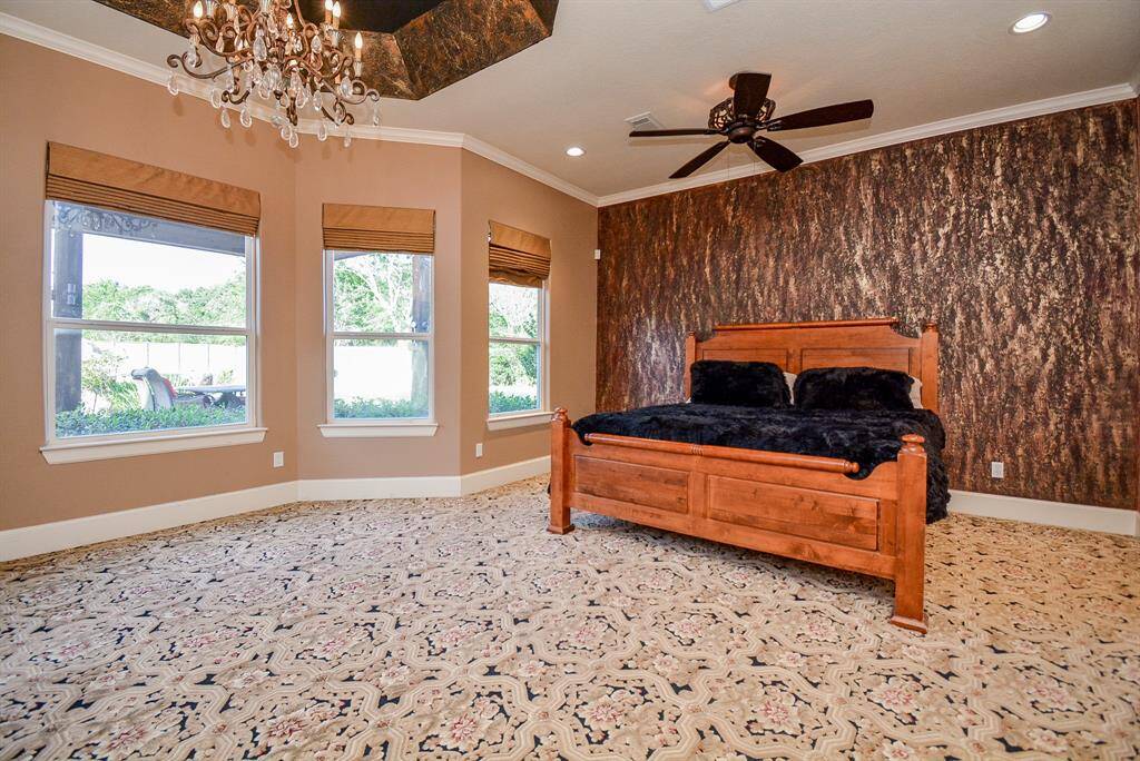Rich tray ceiling detail is borrowed from the accent wall behind the great king bed, seen here. A curved wall of windows brings sunshine in the morning and the dark, romantic skies of night. Your biggest, comfiest, overstuffed pieces will find a happy home in this suite.