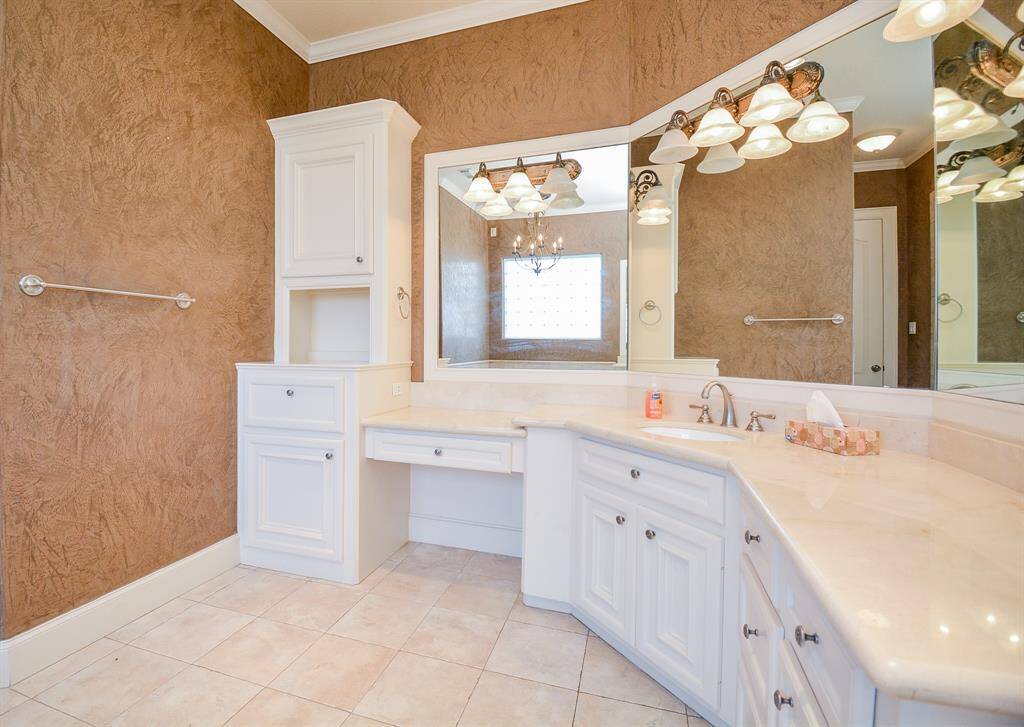 This neat, compact, curved wall housing snow white cabinetry, is complemented by huge mirrors with delicate lighting above. This is refined elegance, at its best.