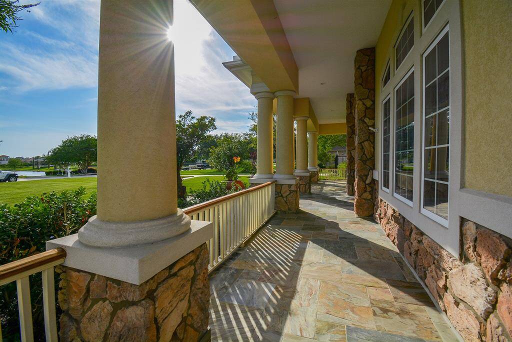 This stone-floored, endless front porch, offers a perfect front row seat to the arrival of summer! Artisan workmanship and classic columns adorn a common, front gathering spot, like no other.
