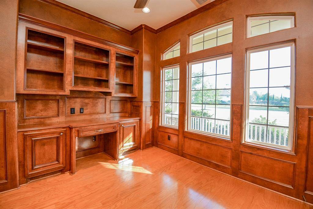The warming, embracing vibe in this front library/study provides the kind of peace, quiet and tranquility you need for serious work and/or meditation, under a wall of arched windows for glorious natural light.