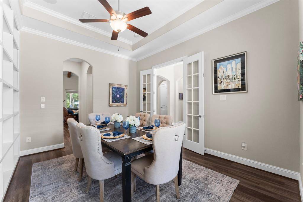 Another view of the formal dining room which features a tray ceiling, archway to butler's pantry, wet bar and kitchen.  Also featured are French doors for added privacy and the flexibility to make this room more private for a second home office.