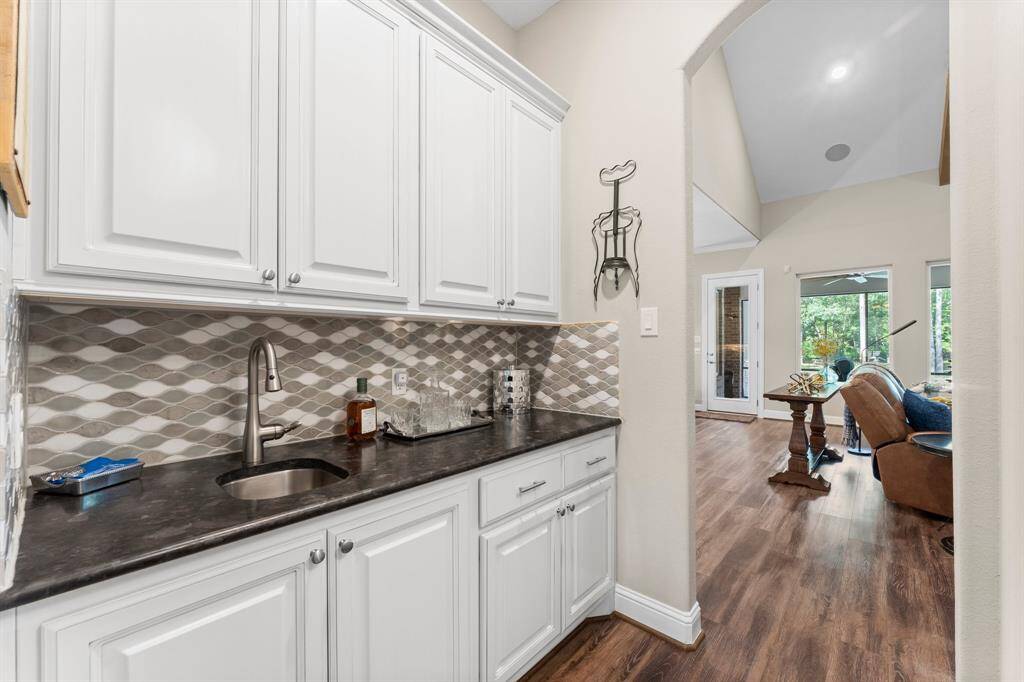 Featuring a sink with a dazzling backsplash, luxurious leathered granite countertops, and generous cabinetry, this elegant space seamlessly connects the heart of the home - the kitchen and family room - to the formal dining room, creating the perfect flow for hosting gatherings.