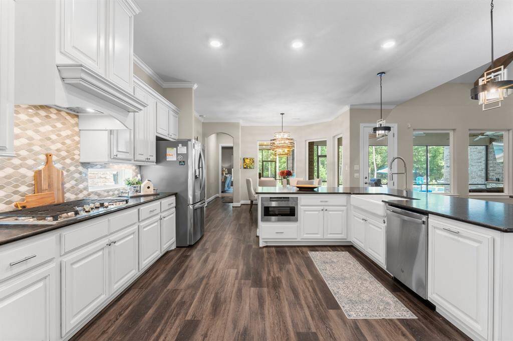 Featuring crisp white cabinetry that exudes timeless elegance, gleaming stainless steel appliances for the modern chef, and a beautiful farmhouse sink that adds a touch of rustic charm.