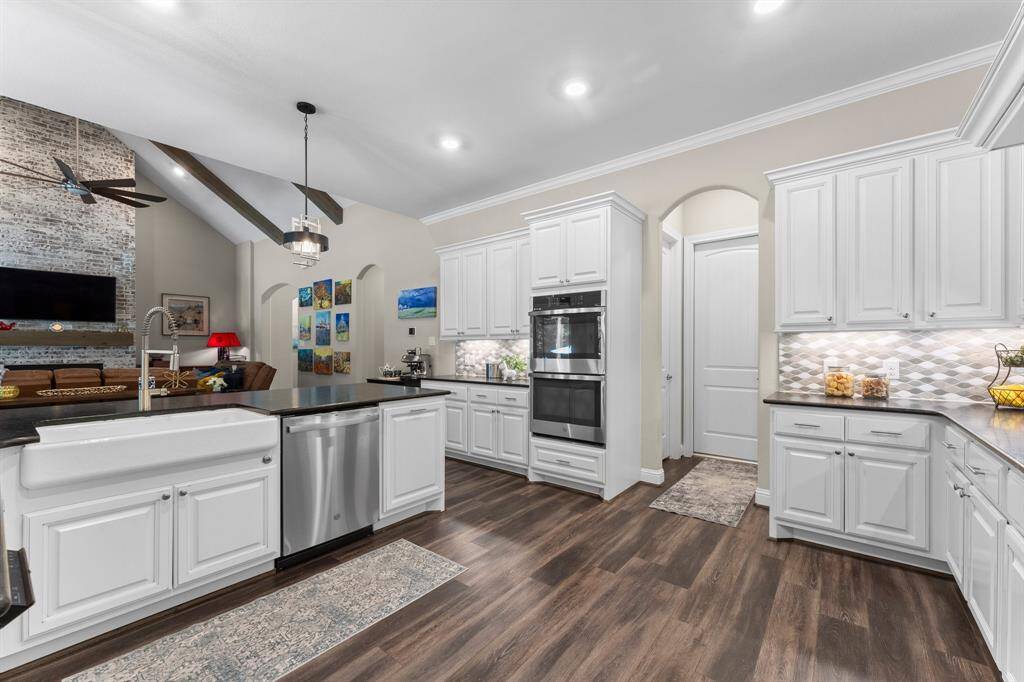 Boasting double ovens for effortless meal preparation, this space seamlessly connects to the convenience of an attached oversized, 3 car garage and a dedicated laundry room, as well as a generously sized walk-in pantry with Elfa Shelving.