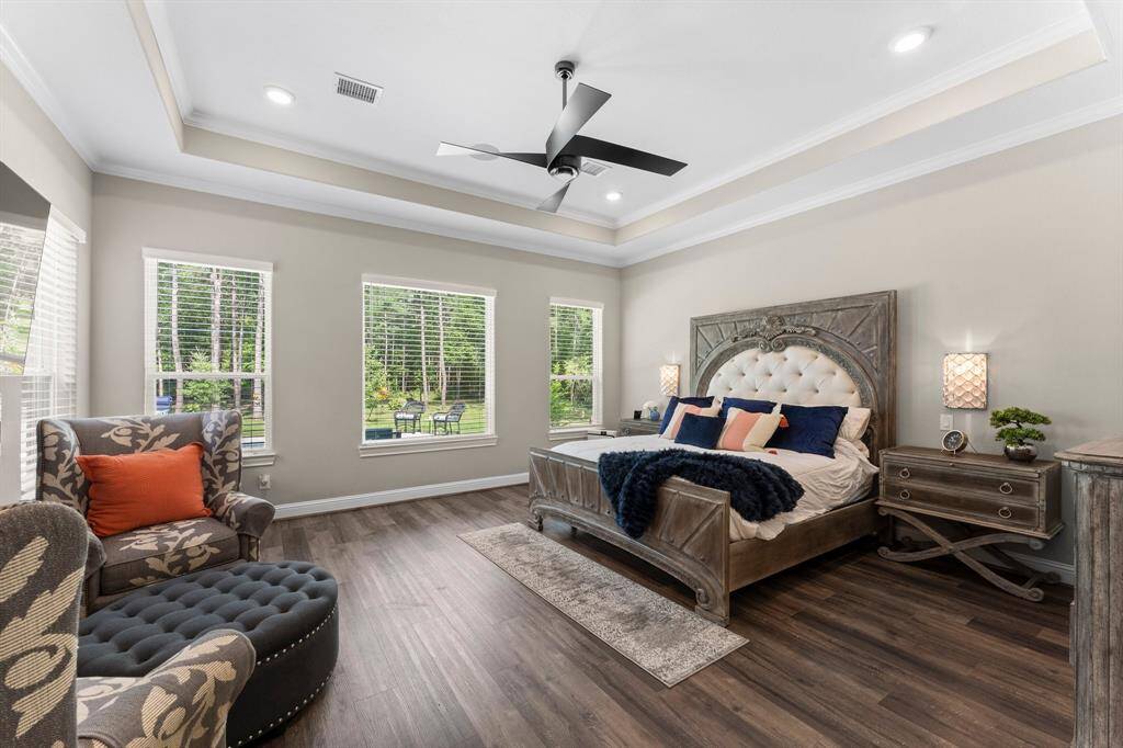 The primary retreat boasts expansive windows that flood the space with natural light, elegant tray ceiling, and stylish ceiling fan. This spacious haven provides the perfect ambiance for relaxation and rejuvenation.