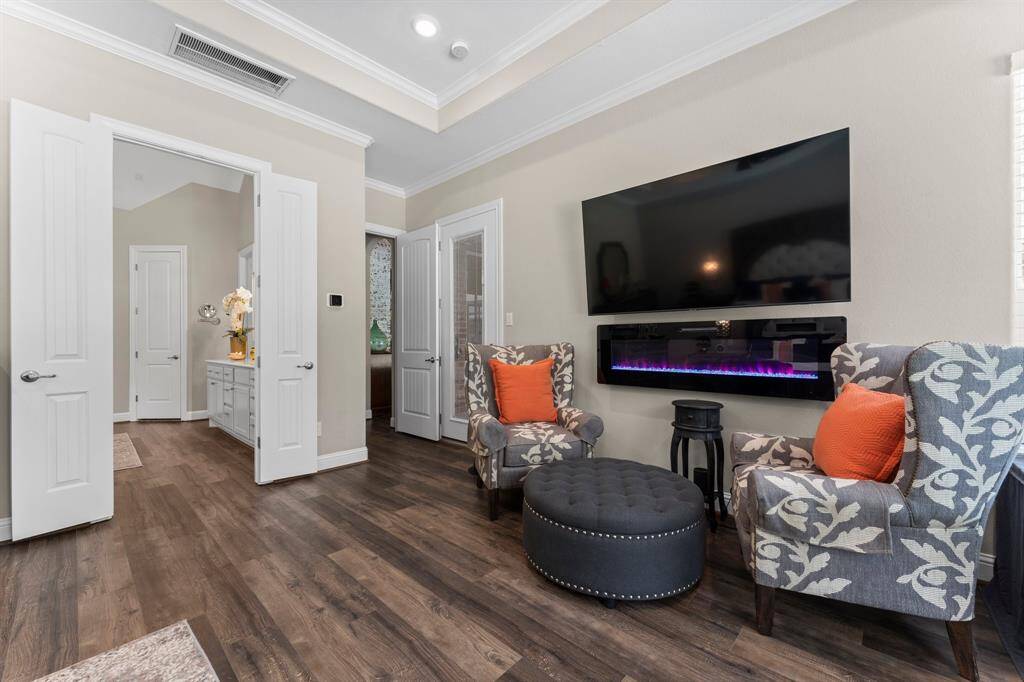 This view showcases private access to your screened back porch through the glass door. Just steps away, discover the luxurious en-suite bathroom through the double doors.