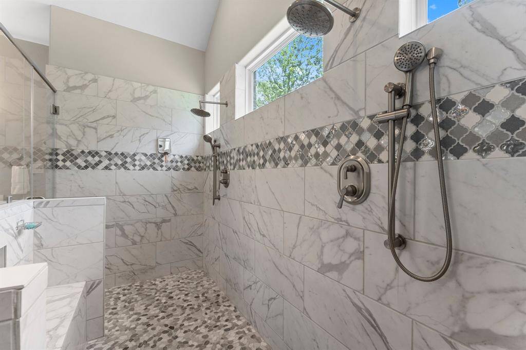 Indulge in the spa-like experience of this expansive shower. Featuring stunning tile work, dual shower stations, and a convenient built-in bench, this is more than just a shower – it's a retreat within your own home.