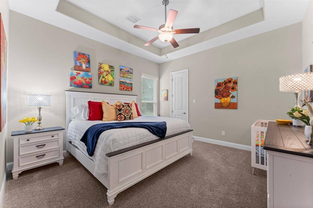 Another generously sized secondary bedroom with tray ceiling and ceiling fan offering maximum comfort and relaxation.