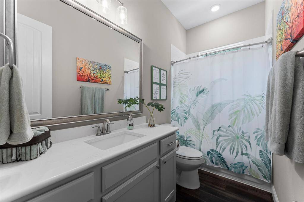 Indulge in the comfort of the secondary bathroom, boasting a spacious vanity and a bright, light-filled atmosphere.
