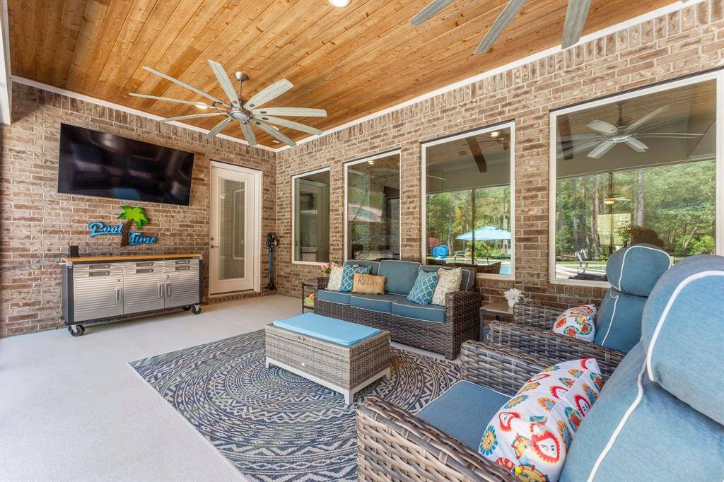 Another view of this amazing screened back porch highlighting the wood ceilings and brick exterior of the home.