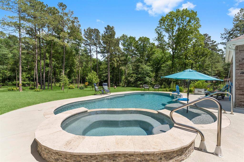 This gorgeous pool features a large hot tub with hand rails for both the hot tub and pool.