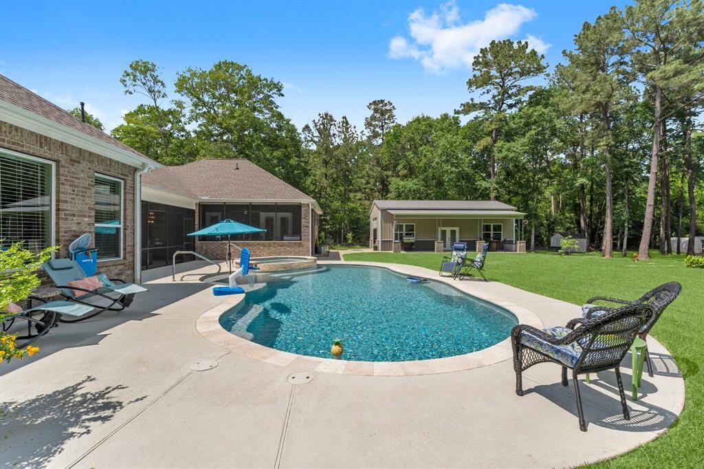 Another view of the pool and backyard with the metal storage building in the distance.