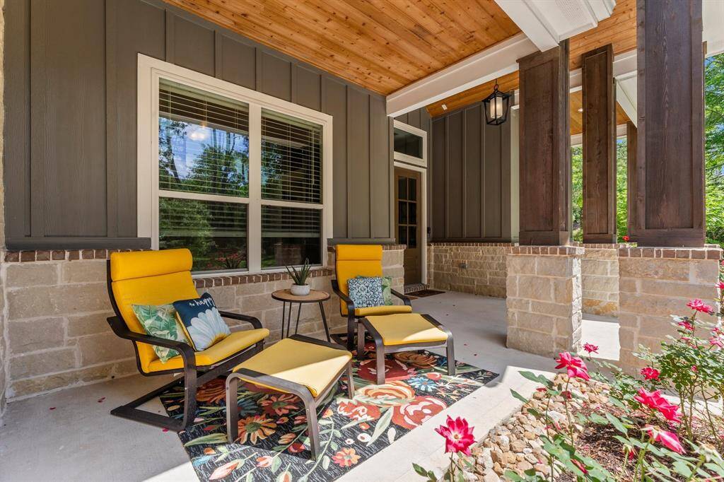Relax and unwind on the lovely front porch of this home while enjoying the front of your property.  Architectural details like the wooden ceiling and stone and brick trim add character and charm.