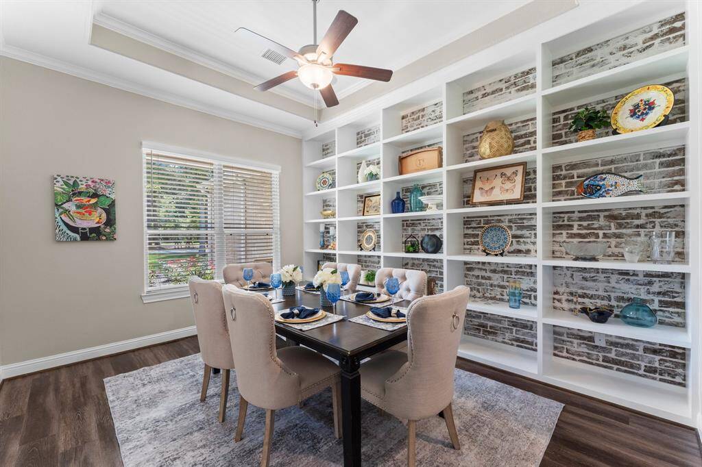 To the left of the welcoming entry, discover a gorgeous, formal dining room. This elegant space is further enhanced by custom-built shelves, perfect for showcasing your cherished collectibles and adding a touch of personalized sophistication. Imagine hosting unforgettable dinner parties in this refined setting!
