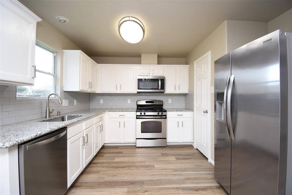Crisp, clean, and oh-so-chic! Loving the vibe in this kitchen with its stunning white cabinets. It’s all about that fresh look! The elegant kitchen also boasts stainless steel appliances, adding a touch of modern sophistication.