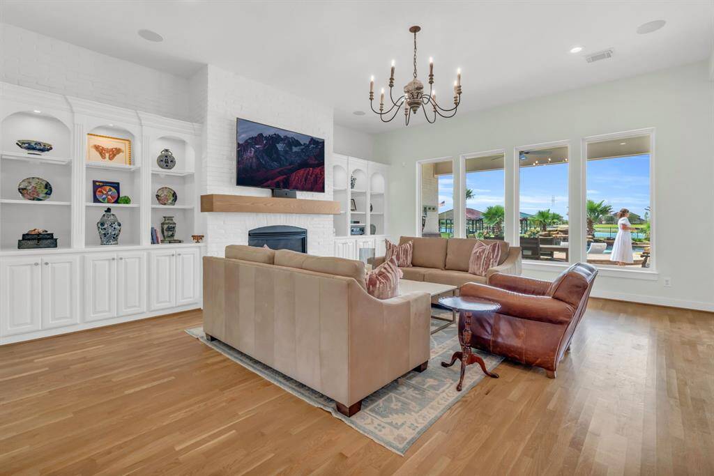 This large Family Room features high Ceilings, Custom Built Ins, Gas Log Fireplace & Large Windows overlooking the Backyard Area! 27103 Boater's Crossing Dr., Katy, TX  77493