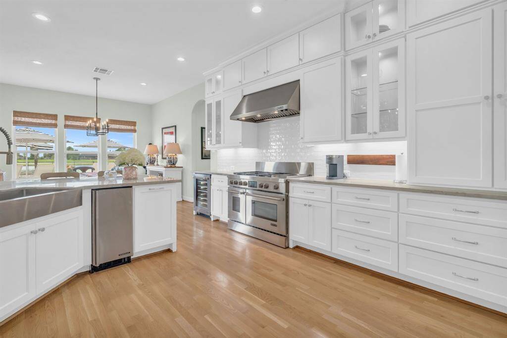 This kitchen features Custom Cabinets w/Glass Doors & Under Mount Lighting & a Gas Range w/SS Vent Hood! 27103 Boater's Crossing Dr., Katy, TX  77493