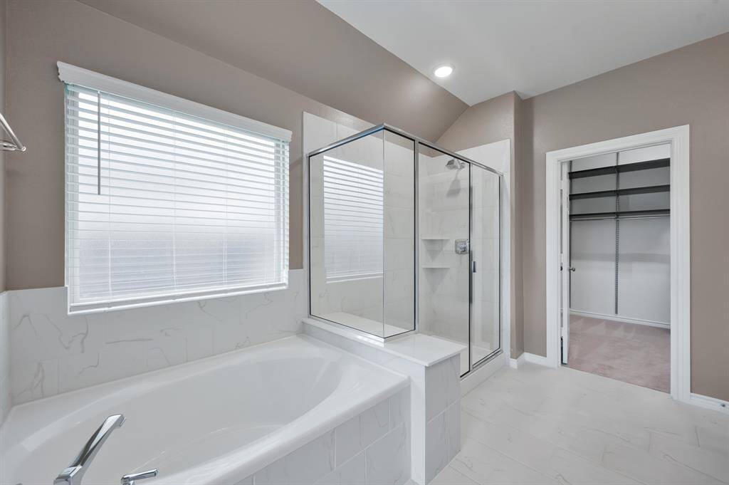 Ensuite bathroom features a large soaking tub and expansive shower.